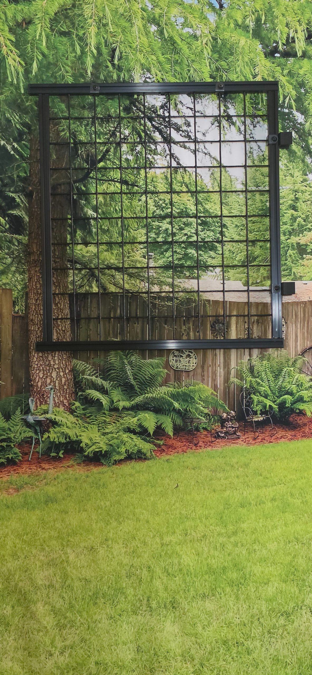 Black metal garden trellis hanging in backyard
